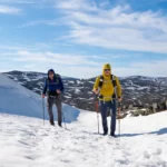 Miehet vaeltavat lumisessa tunturissa